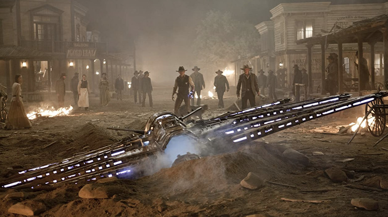 The cowboys standing in front of a crashed alien spacecraft
