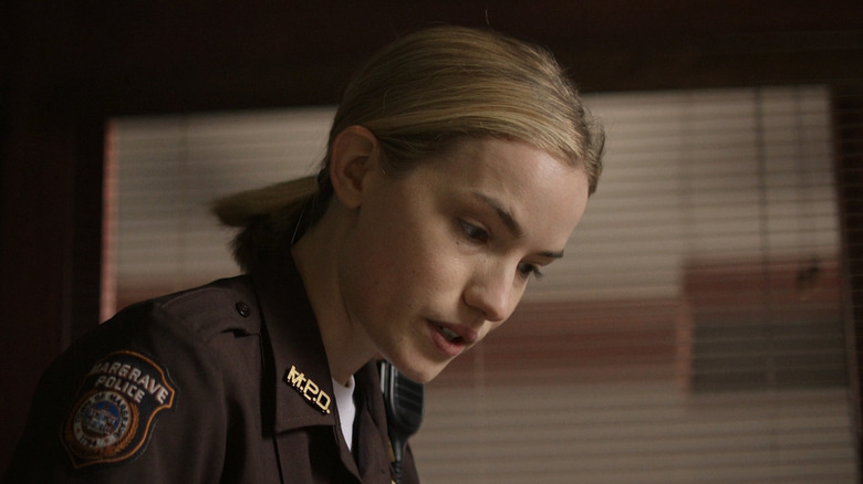 Willa Fitzgerald's Roscoe Conklin looks down at something offscreen in Reacher