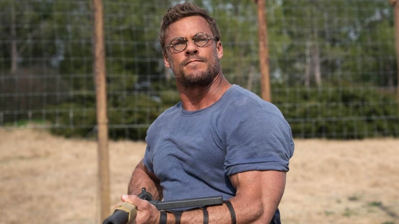 Alan Richson as an atrist carrying a gun