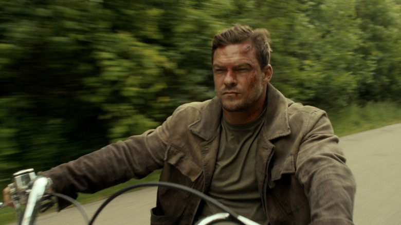 Alan Ritchson as Jack Reacher rides a motorcycle in Reacher