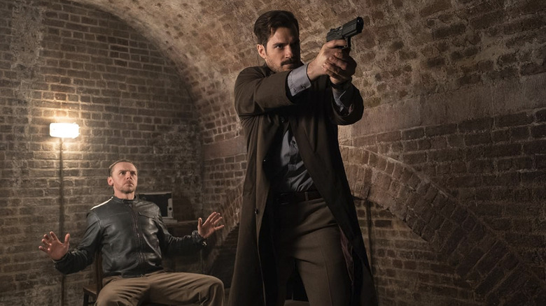 John Lark points a gun at someone while Benji sits behind him in Mission: Impossible — Fallout