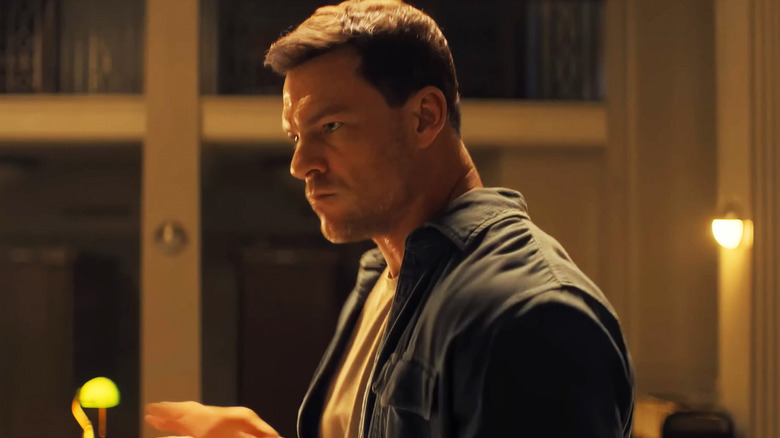 Alan Ritchson's Jack Reacher stands in a library in Reacher