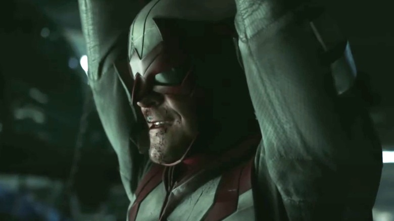 Hank Hall dari Alan RItchson tersenyum saat dia berdiri dengan tangan terangkat dalam kostum Hawk di Titans