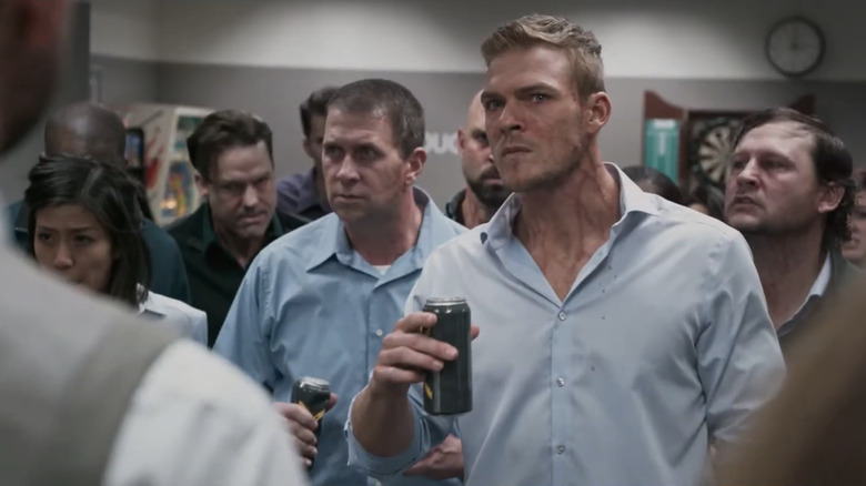 Alan Ritchson's Bob stands with his coworkers drinking a can of Zolt in Office Uprising