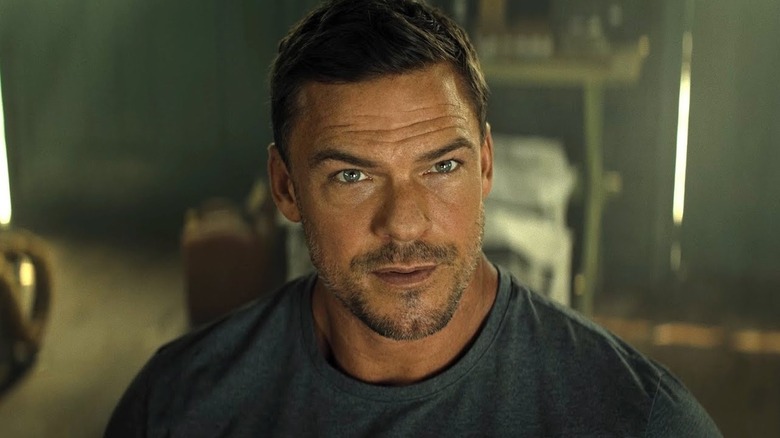 Alan Ritchson as Jack Reacher looking thoughtful on Reacher