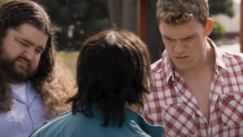 Alan Ritchson's Kip Loyola/Carew stands next to Jorge Garcia's Lurch/Garvey as they talk to someone with their back to the camera in The Wedding RInger