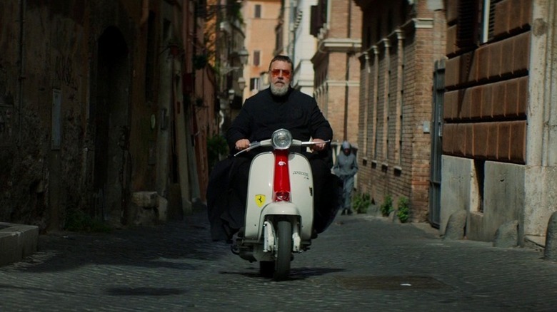 Russell Crowe as Father Gabriele Amorth riding scooter in The Pope's Exorcist