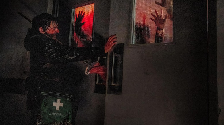 Bryan tries to barricade a door from zombies in Resident Evil