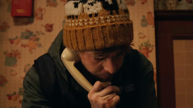 Bryan (Austin Abrams) holding a phone receiver in "Resident Evil"