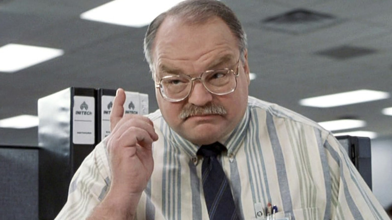 Richard Riehle as Tom pointing his finger in the air in Office Space