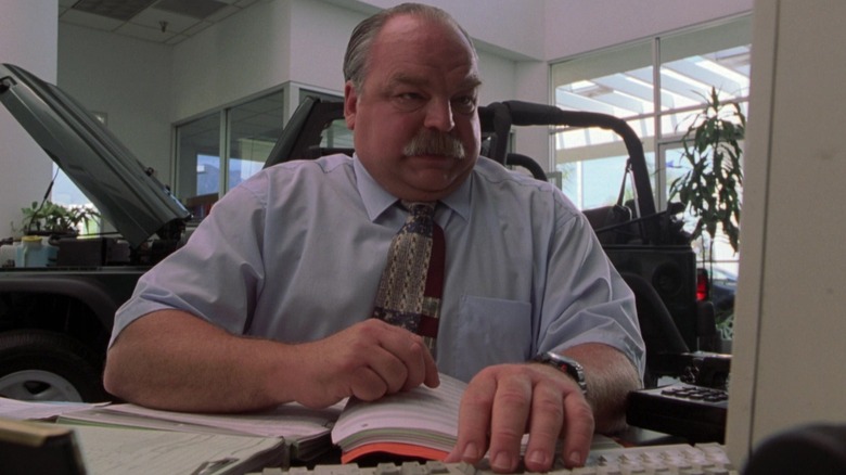 Richard Riehle as the car dealer at his computer in Joe Dirt
