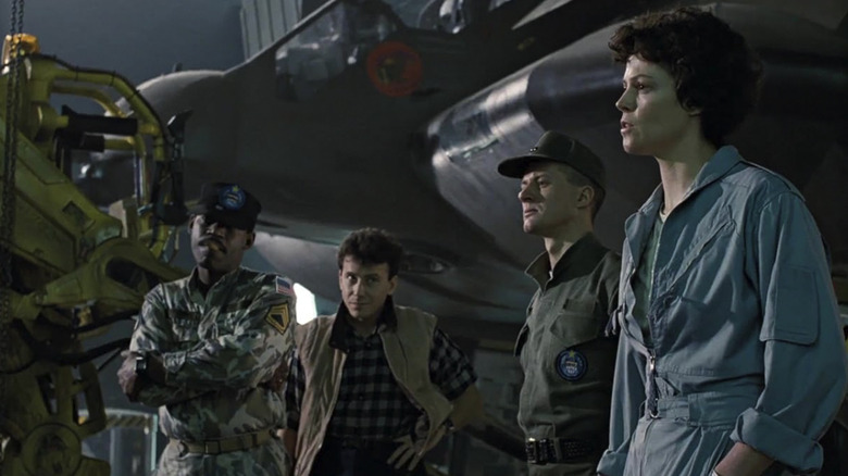 Ellen Ripley surrounded by agents in a hangar in Aliens