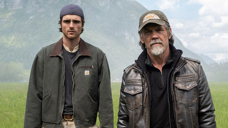 Jacob Elordi as Hig standing next to Josh Brolin as Bangley in a field in The Dog Stars