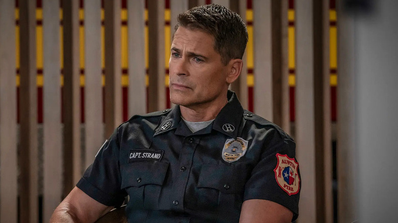 Rob Lowe's Owen Strand wearing a firefighter uniform and looking concerned on 9-1-1: Lone Star