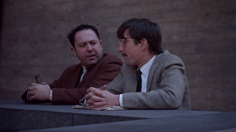Jon Rubin chatting with a friend art a counter in Greetings
