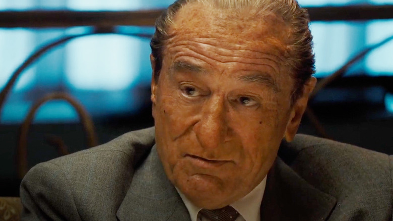 Robert De Niro as Frank Costello sitting at a dinner table in The Alto Knights