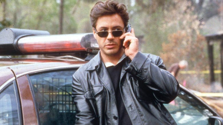 Robert Downey Jr. leans against a cop car as Clyde Pell in The Gingerbread Man