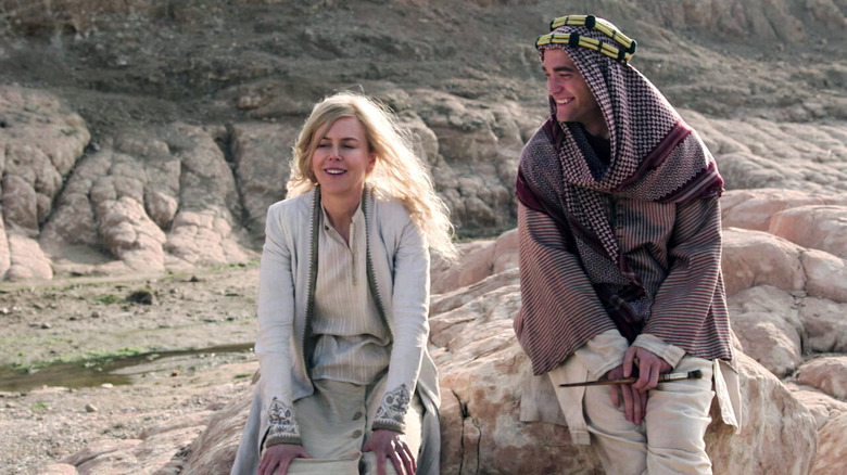 Gertrude Bell and T.E. Lawrence laughing on some rocks in Queen of the Desert