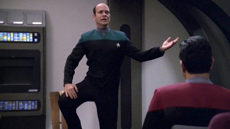 Robert Picardo as the Doctor standing on a chair and singing in front of the crew in Star Trek: Voyager