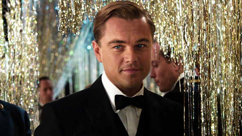 Jay Gatsby (Leonardo DiCaprio) donning a black suit and tie at one of his parties in "The Great Gatsby"