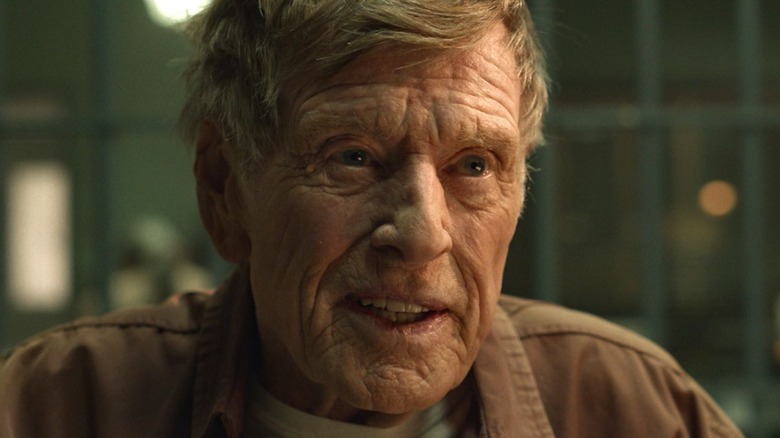 Robert Redford as a prisoner looking stern inside a cell on Dark Winds