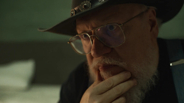 George R.R. Martin as George wearing a cowboy hat and looking thoughtful on Dark Winds