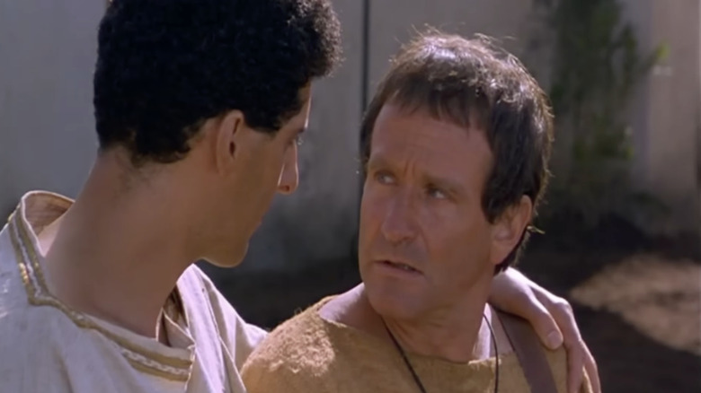 John Turturro as Lucinnius puts his arm around Robin Williams as Hector's shoulder in Being Human