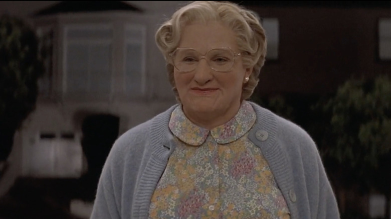 Daniel Hillard (Robin Williams) disguised as Euphegenia Doubtfire stands on a porch in Mrs. Doubtfire