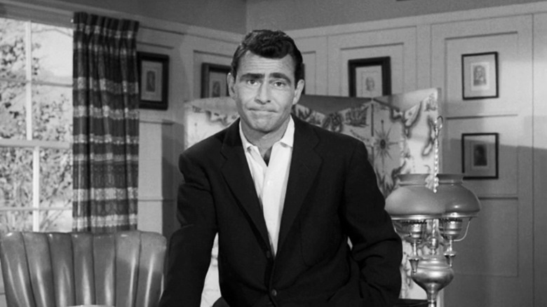 Rod Serling sits on a desk in The Twilight Zone