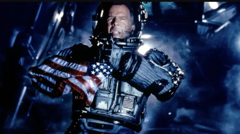 Bruce Willis' Harry S. Stamper holds a US flag as he stands in a space suit in Armageddon