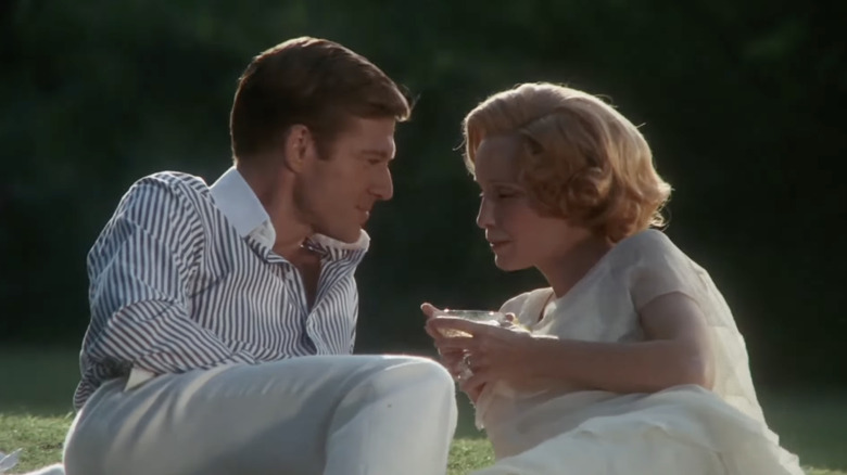 Robert Redford as Jay Gatsby and Mia Farrow as Daisy Buchanan chatting on some grass in The Great Gatsby (1974)