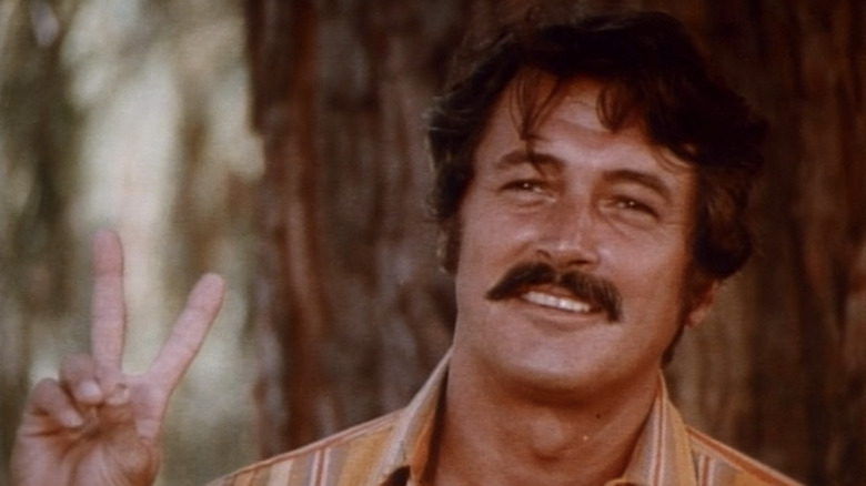 Michael de Rock Hudson "Tigre" McDrew est vu en gros plan alors qu'il brandit le signe de la paix dans Pretty Maids All in a Row