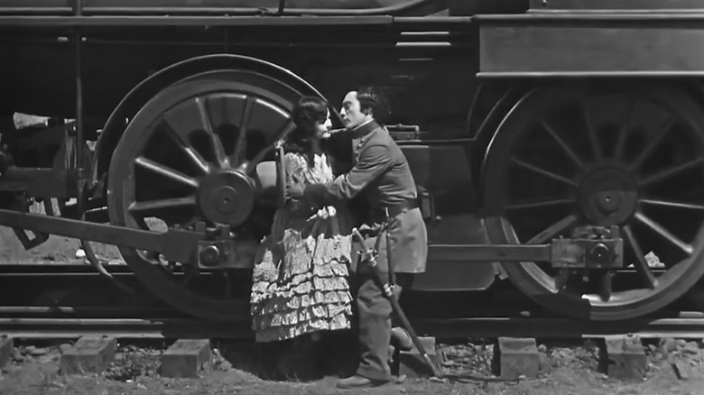 Buster Keaton hugs a woman on train tracks as Johnnie Gray in The General