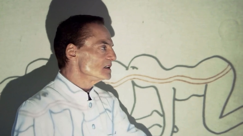 Dieter Laser's Josef Heiter stands in front of a diagram in The Human Centipede First Sequence