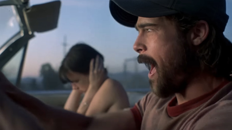 Brad Pitt's Early Grace yells as he drives a car alongside Juliett Lewis' Adele in Kalifornia