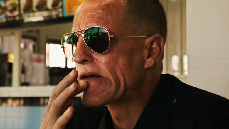Woody Harrelson's David Brown rubs his lip as he sits in a restaurant in Rampart