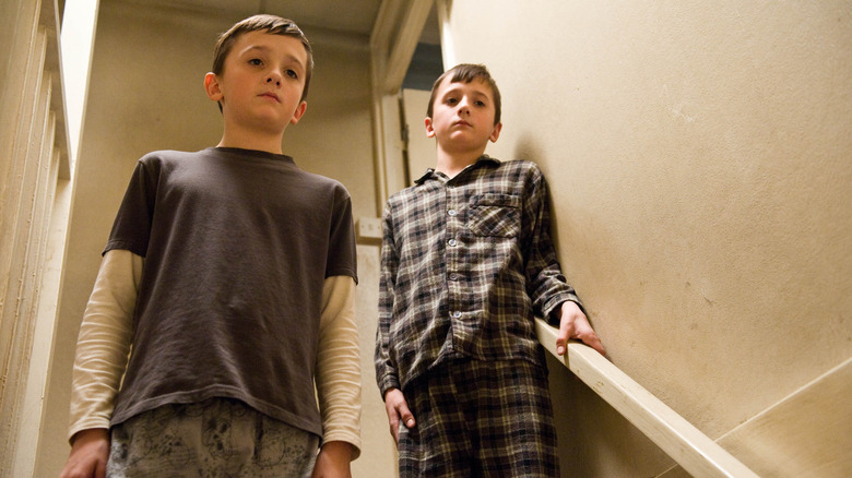 Jason and Marcus standing on a staircase in Hereafter