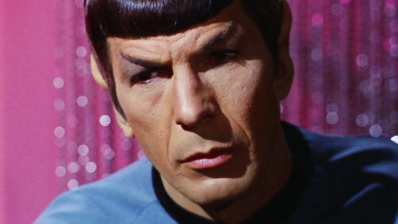 Leonard Nimoy's Spock is seen in closeup against a pink background in Star Trek 