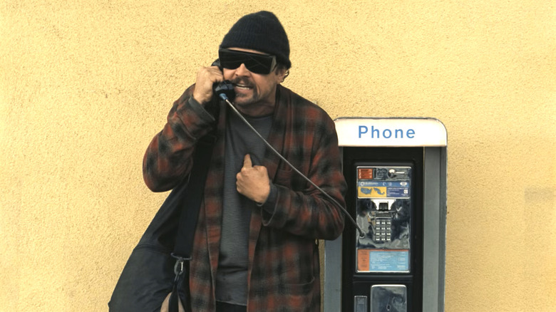 Bob arguing on a payphone in One Battle After Another