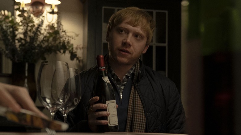 Rupert Grint Servant holding wine bottle