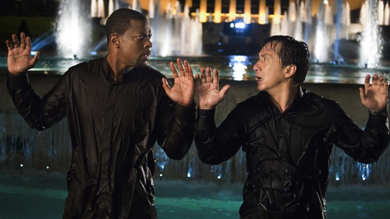 Chris Tucker as Carter and Jackie Chan as Lee soaking wet with their hands raised in Rush Hour 3