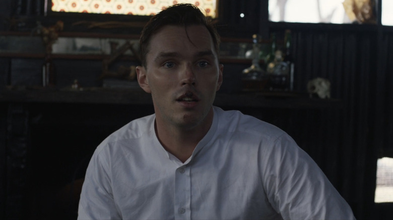 Nicholas Hoult as Constable Fitzpatrick looks surprised as he sits in a dark room in True History of the Kelly Gang