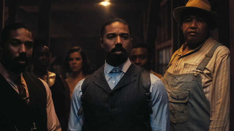 The Smokestack twins (Michael B. Jordan), Annie (Wunmi Mosaku),  Mary (Hailee Steinfeld), Sammie "Preacher Boy" Moore (Miles Caton), and Cornbread (Omar Miller) stare outside the juke joint entrance in "Sinners"