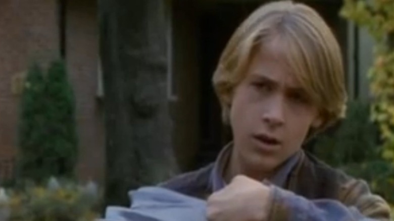 Ryan Gosling as Greg Banks holding a camera in his hands in Goosebumps' Say Cheese and Die