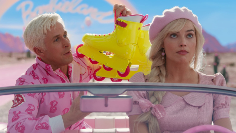 Ryan Gosling and Margot Robbie as Ken and Barbie, riding together in a pink car in Barbie