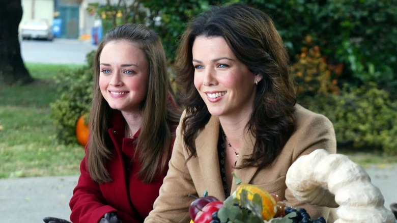 Rory en Lorelai glimlachen en zitten buiten op Gilmore Girls