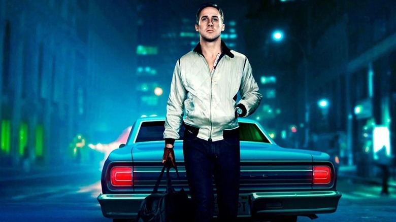 The Driver holding a duffel bag in front of car on Drive poster