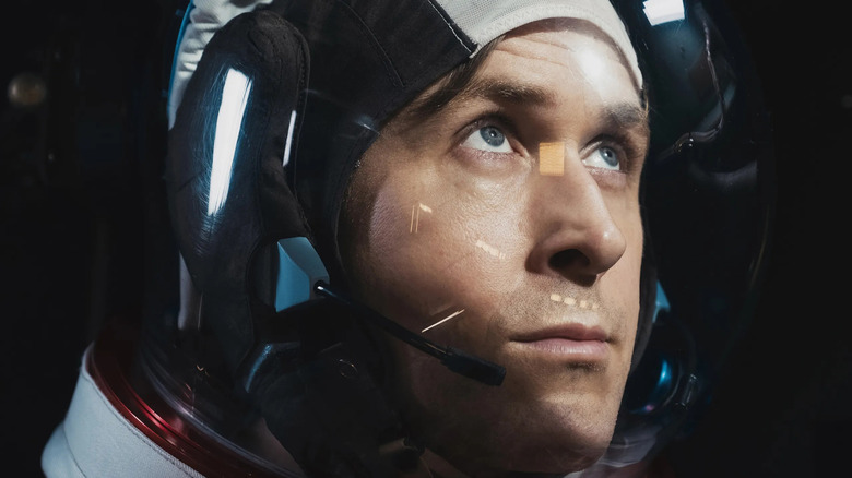 Ryan Gosling as Neil Armstrong in his space costume by looking in the first man