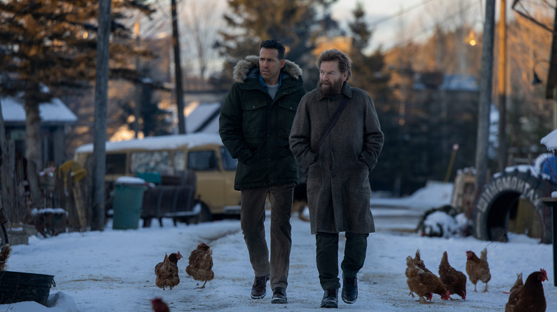 Ryan Reynolds as Troy "Assassin" Kelly and Kenneth Branagh as Nikolai Ustinov walking in the snow by some chickens in Mayday