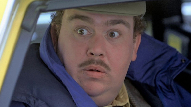 John Candy as Del looking surprised in the back of a taxi in Planes, Trains & Automobiles